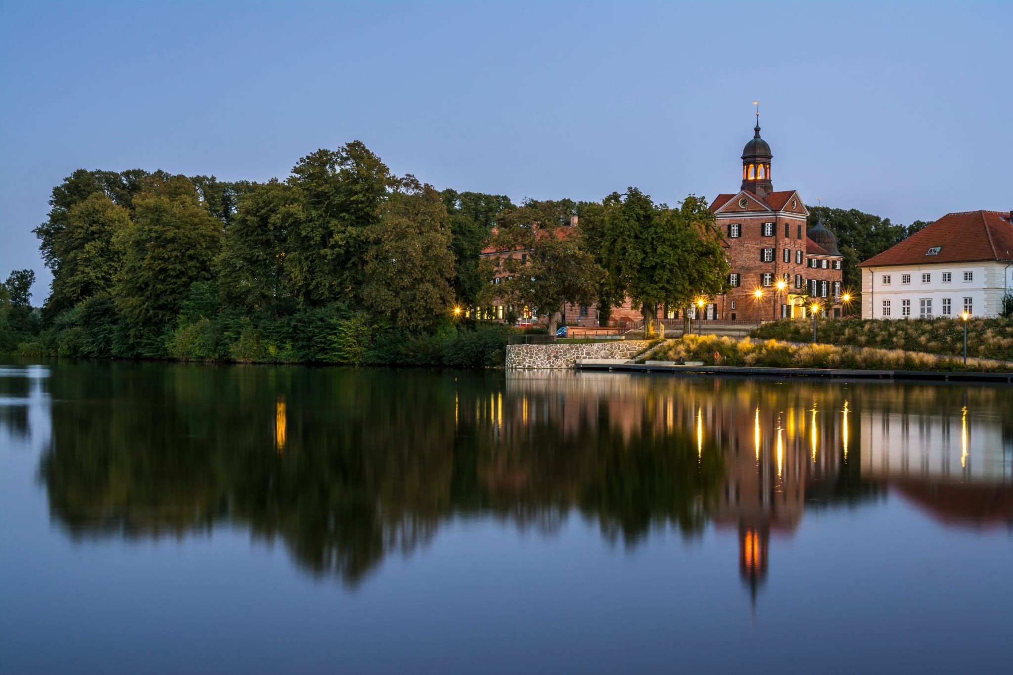 Die Stadt Eutin ist vom Wasser aus bei Abendstimmung zu sehen. 